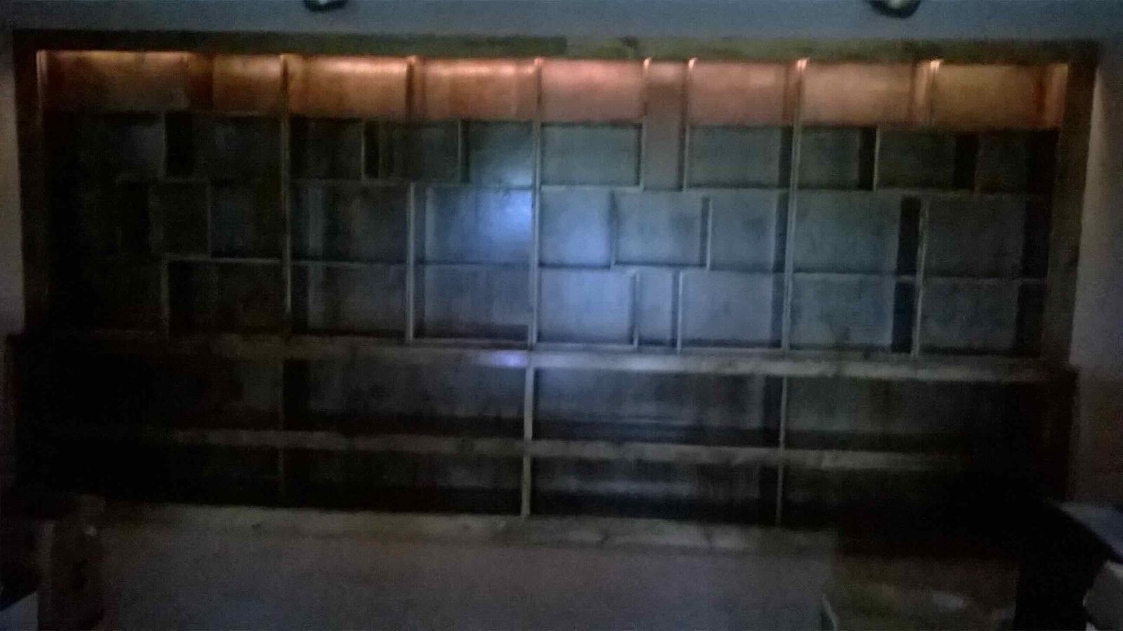 The stained shelving wall.